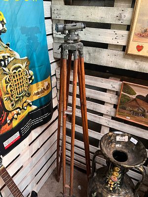 An early 20th century surveyors theodolite with wood tripod stand.