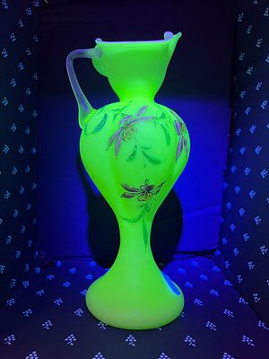 An early 20th century hand blown uranium glass ewer decorated with flowers. 23cm tall