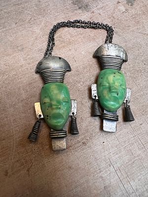 A pair of Art Deco French tribal face mask brooch with bakelite and white metal fitments.