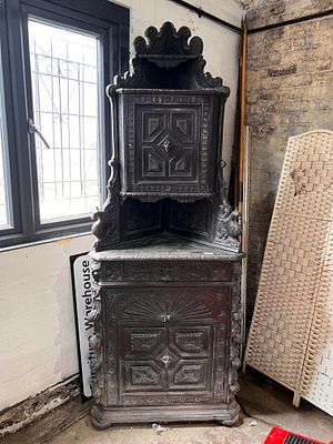 A Victorian gothic heavily carved oak corner cupboard in a Black Forest style.