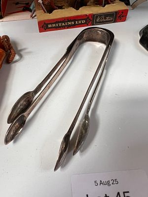 Two pairs of HM silver sugar nips, one plain form and one chase worked. 70g total.