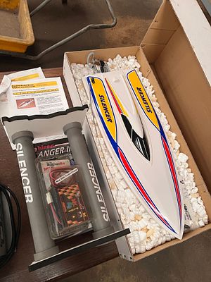 A remote control battery powered speed boat, silencer, stand and radio set.