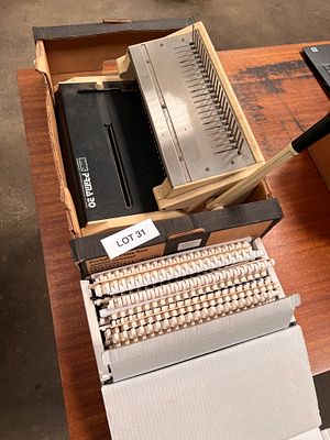 A punching machine for spiral bound paperwork + box of spirals