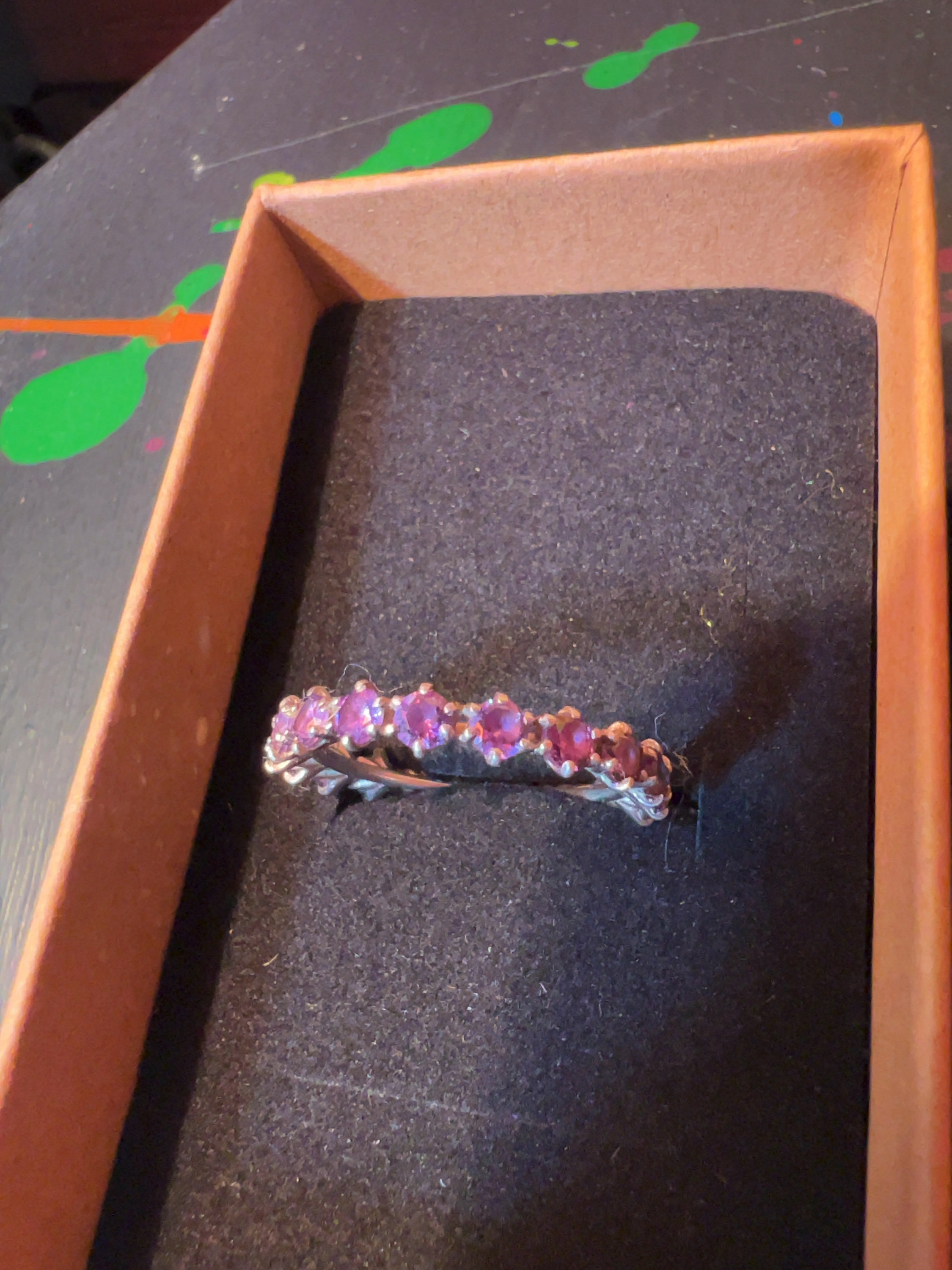 A 925 sterling silver rose gold-tone eternity ring set with pinkish-purple gemstones