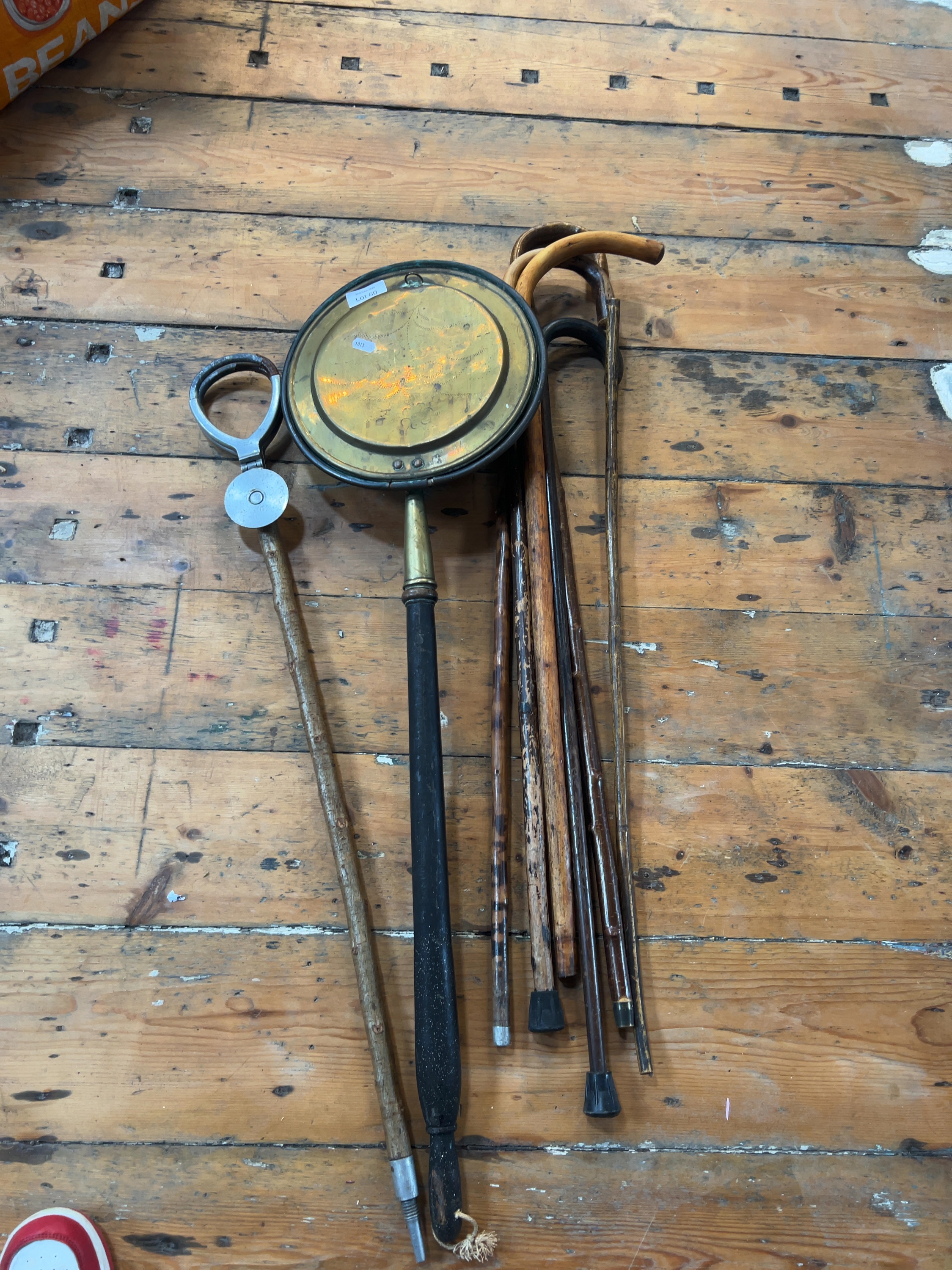 A Collection of Vintage Wooden Walking Sticks, a Brass Warming Pan and a Surveyor's Measuring Tool