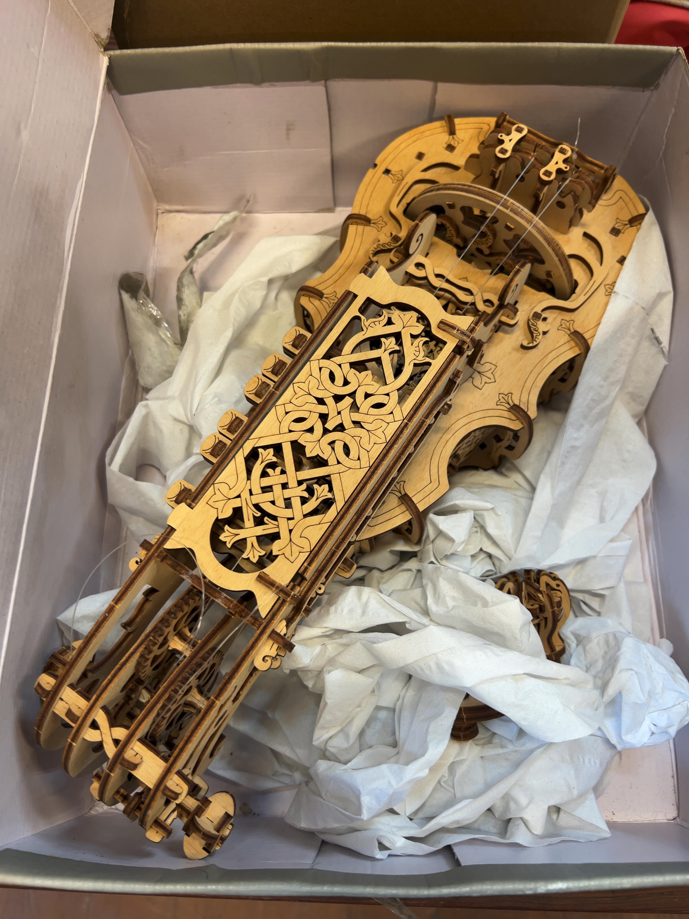 A mechanical wooden model of a hurdy-gurdy, in the style of Ugears