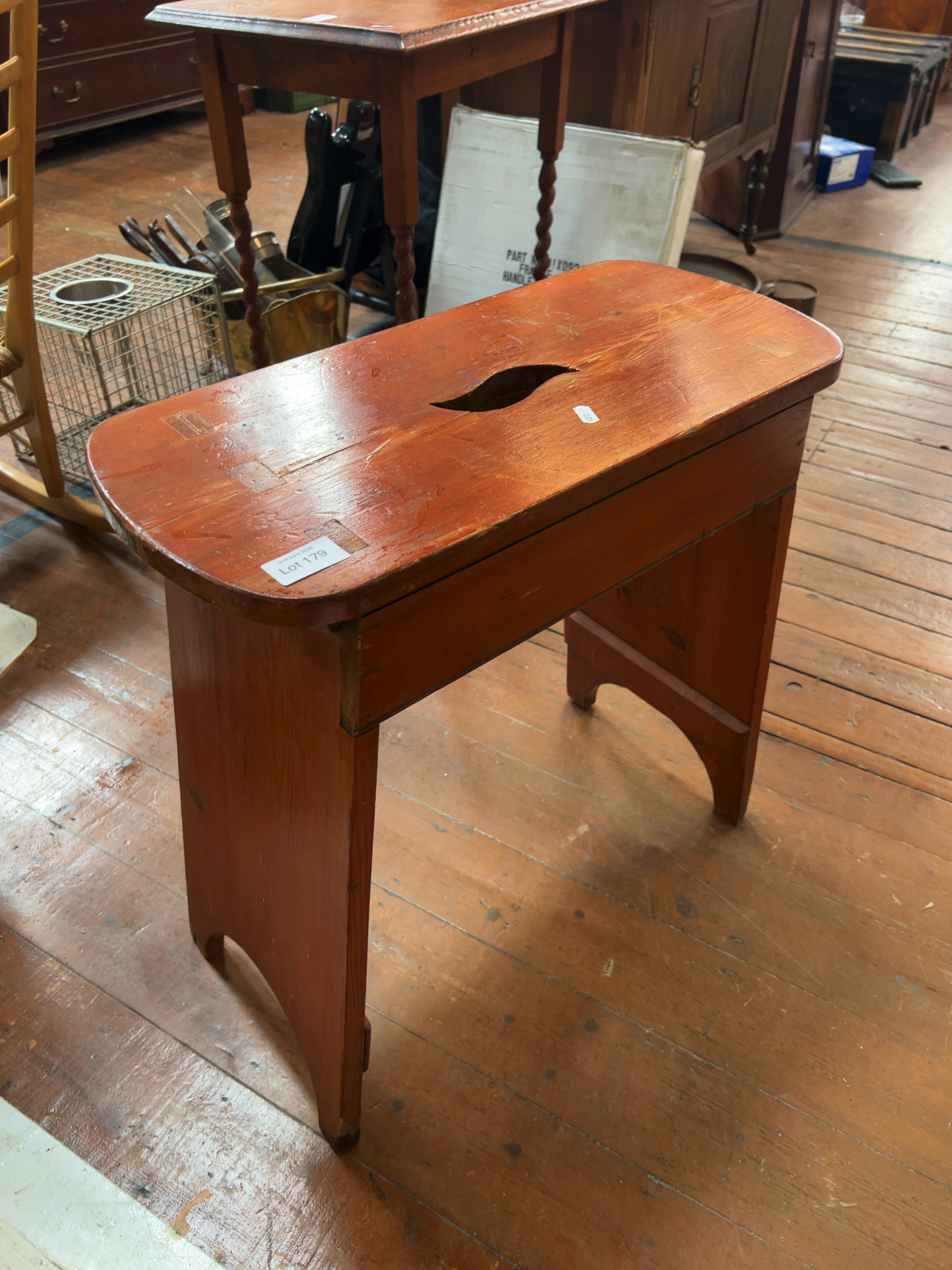 A late 19th or early 20th-century pine hearth stool with central handle cutout