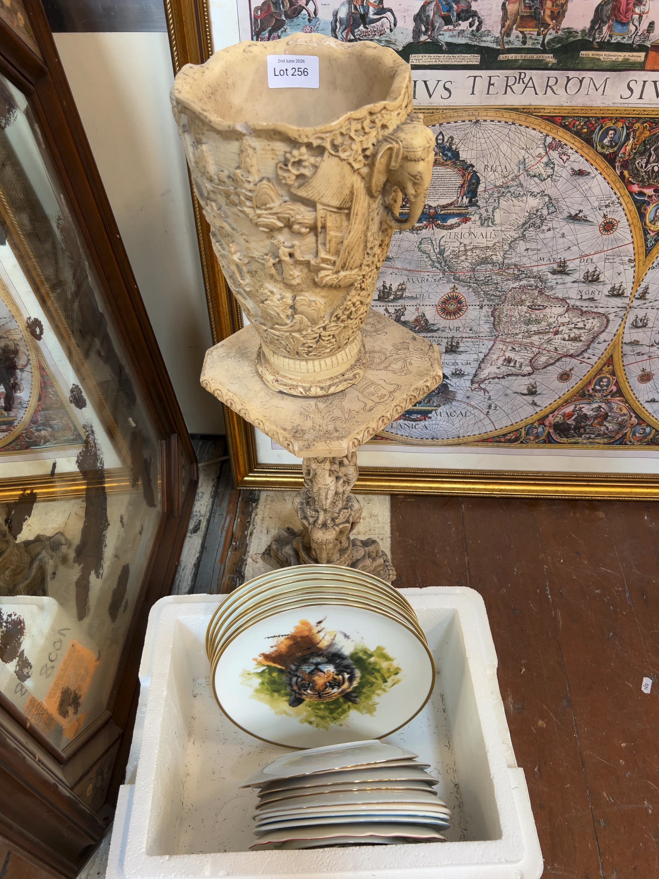 A large Asian-style carved composite vase on matching pedestal stand together with a collection of decorative and collector plates
