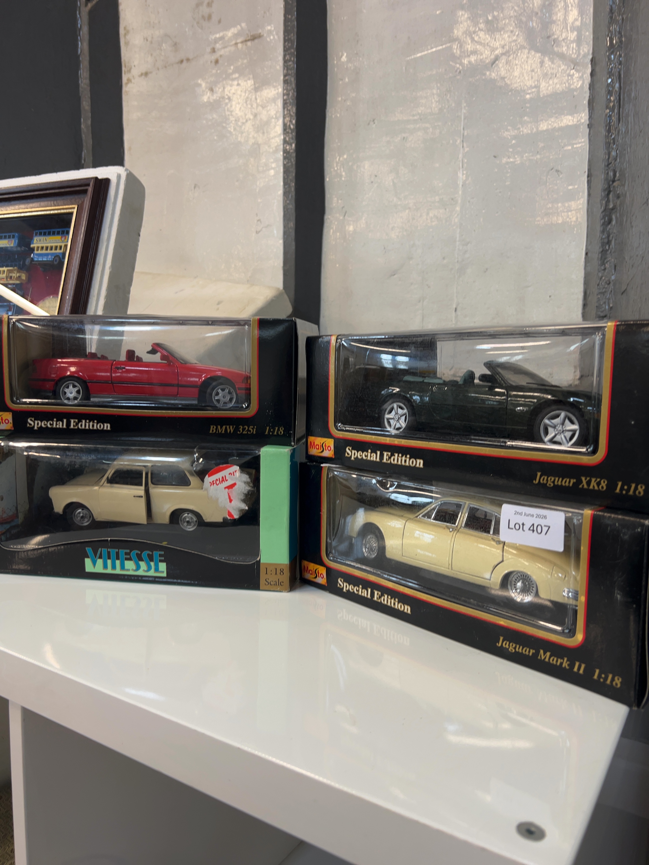 A collection of four 1:18 scale model cars by Maisto and Vitesse
