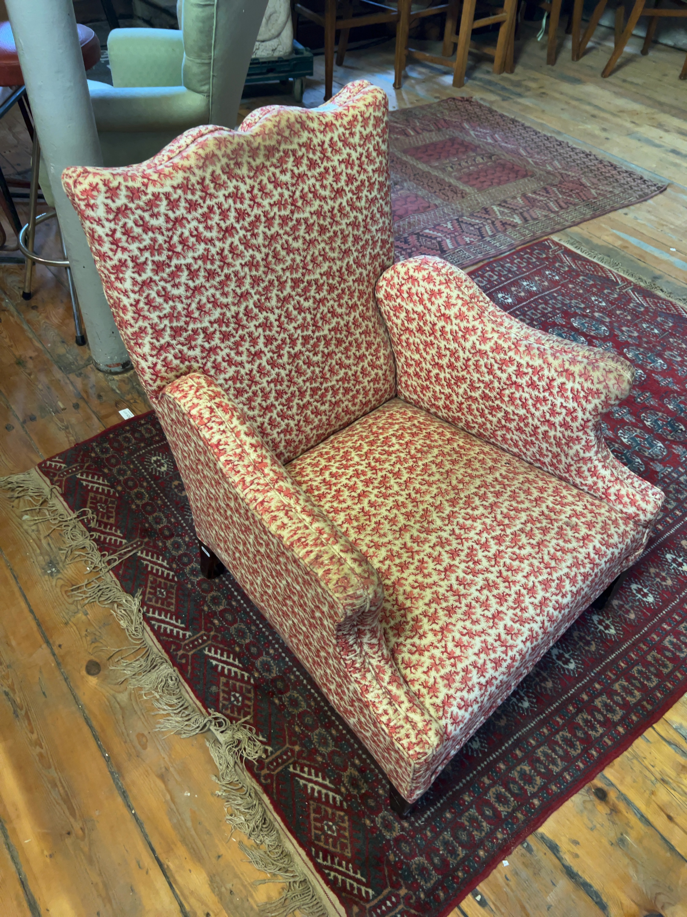 A mid-20th century upholstered easy chair with scalloped back