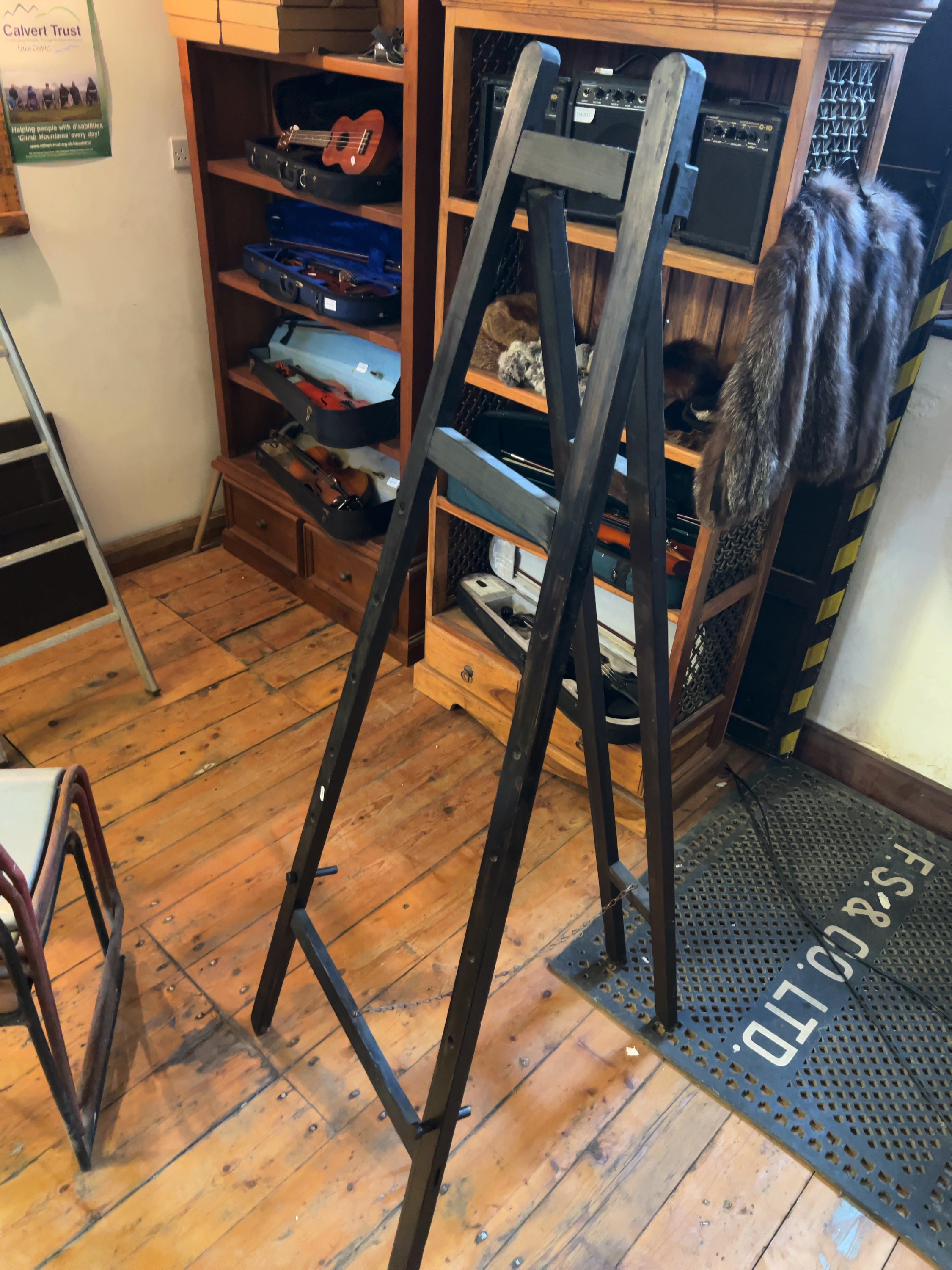 A large dark-stained wooden A-frame studio easel