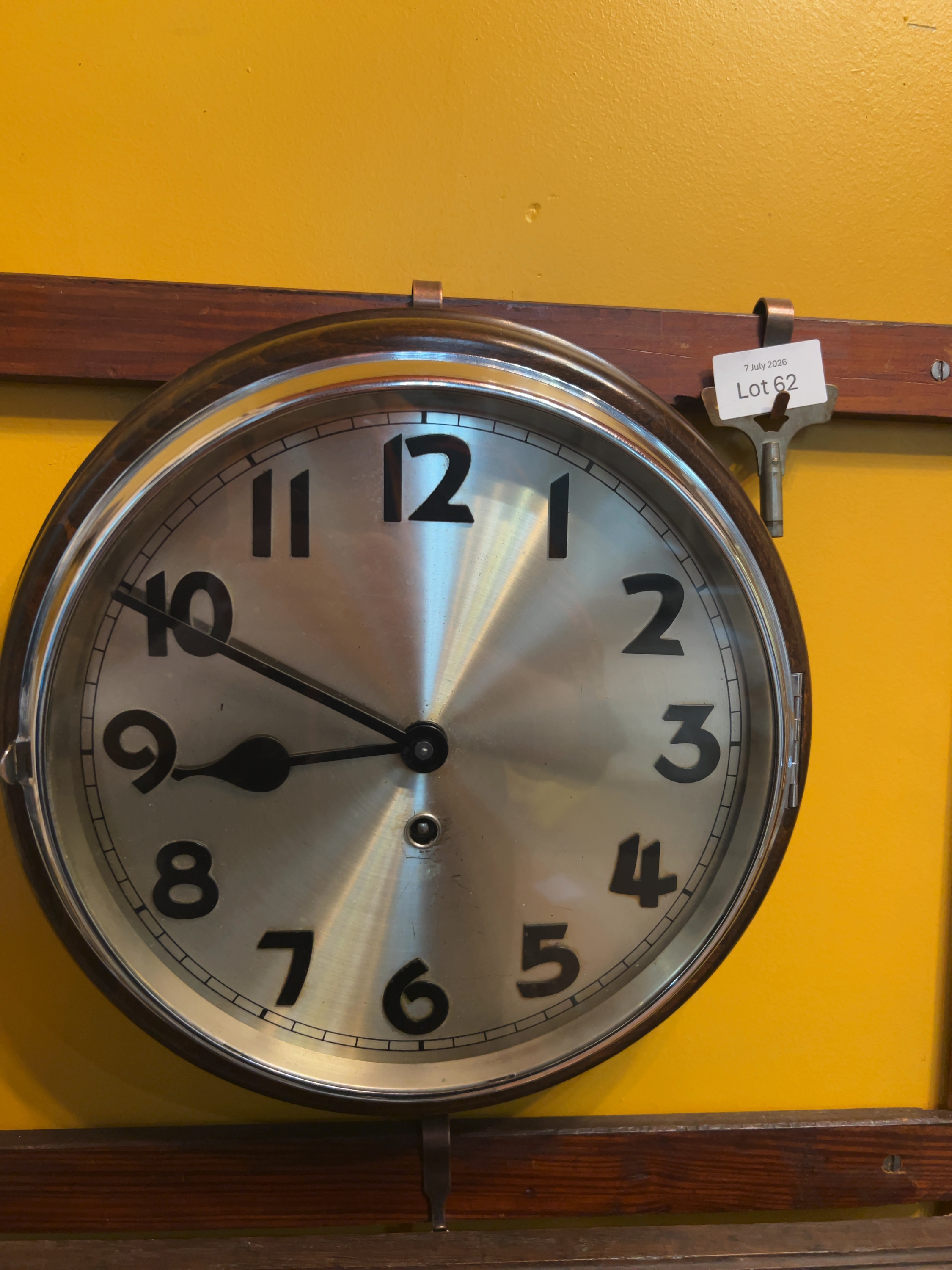 A mid-20th-century mechanical dial wall clock with a silvered dial