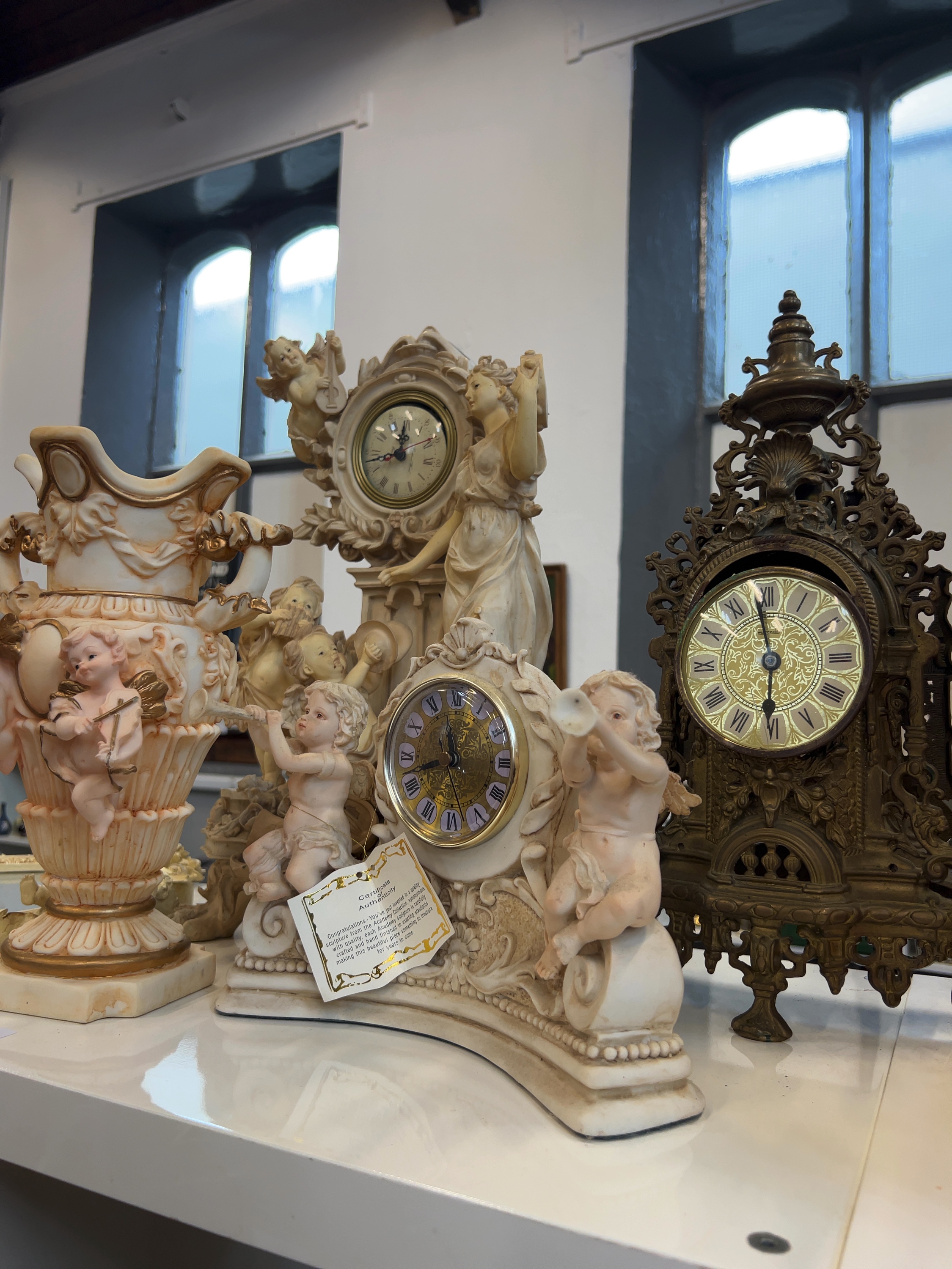 Five Rococo and Neoclassical Revival Style Decorative Items including Academy Collection Figural Clocks and a Cast Metal Mantel Clock