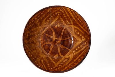 A SLIP-DECORATED BROWN GLAZED BOWL, POSSIBLY NISHAPUR. Khurasan or Nishapur, Ca. 10th - 11th 