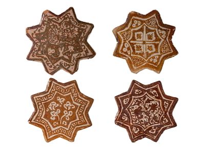 A GROUP OF FOUR QAJAR LUSTRE-PAINTED STAR TILES. Iran, Ca. 17-18th century AD or later. A group 