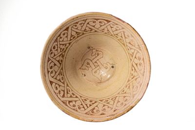 A NISHAPUR SLIP-PAINTED EARTHENWARE SGRAFITTO BOWL. Eastern Iran or Central Asia, Ca. 11th - 