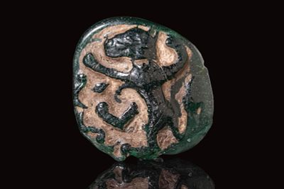 A GREEN GLASS FATIMID WEIGHT OR INLAY, POSSIBILY DEPICITNG SAGGITARIUS. Ca. 12th - 13th century 