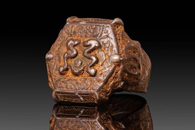 AN ISLAMIC ENGRAVED BRONZE RING WITH GEOMETRIC AND SCROLL DECORATION. Ca. 12th century AD. A 