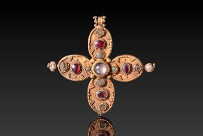 BYZANTINE HIGH KARAT GOLD CROSS WITH CABOCHONS. Ca. AD 600 . A gold cross pendant formed of four 