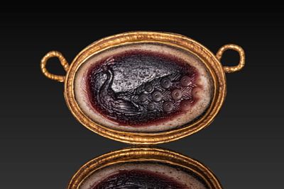 BYZANTINE HIGH KARAT GOLD PENDANT SET WITH GLASS INTAGLIO DEPICTING A PEACOCK. Ca. AD 300 - 500. 
