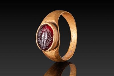 BYZANTINE HIGH KARAT GOLD RING WITH GARNET INTAGLIO DEPICTING A HOLY BRANCH. Ca. AD 500 - 700. 