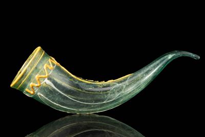 MEROVINGIAN GLASS DRINKING HORN. Ca. AD 400 - 600. A translucent green glass drinking horn with 