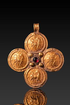 BYZANTINE HIGH KARAT GOLD CROSS WITH CENTRAL RED GARNET CABOCHON AND FOUR QUADRUPEDS. Ca. AD 600 
