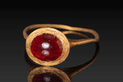 MEROVINGIAN HIGH KARAT GOLD RING WITH RED GARNET CABOCHON. Ca. AD 400 - 600. A gold ring 