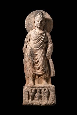 GANDHARAN STONE RELIEF OF STANDING BUDDHA. Ca. AD 300 - 400. A finely modelled standing figure 