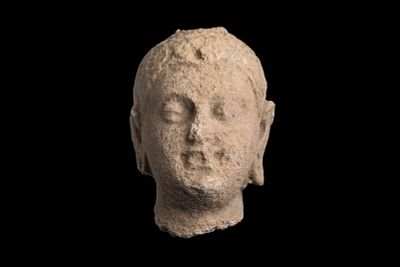 GANDHARAN STONE HEAD OF BUDDHA. Ca. AD 300 - 400. A stone carved head of Buddha, shown with a 