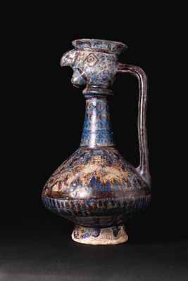 KASHAN BLUE AND BLACK GLAZE BIRD-HEADED JUG. Ca. 12th - 13th century AD. A blue and black glazed 