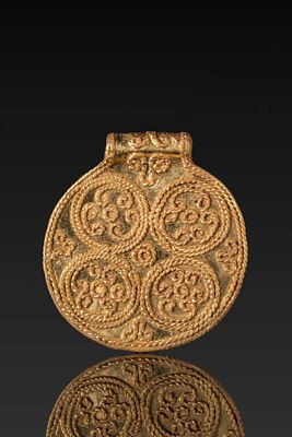 SCANDINAVIAN VIKING HIGH KARAT GOLD CIRCULAR PENDANT WITH SCROLLWORK. Ca. AD 650 - 750. A gold 