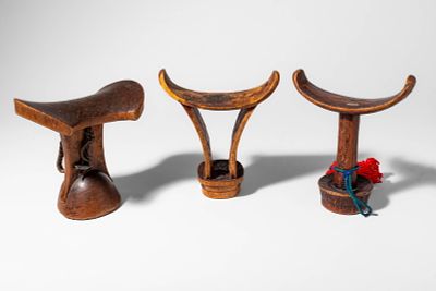 GROUP OF THREE AFRICAN HEADRESTS. Ca. 19th - 20th century AD. >A group of three carved wooden 