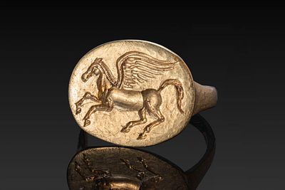 GREEK HELLENISTIC GOLD RING WITH PEGASUS. Ca. 400 BC. A gold ring with a flat-section hoop 
