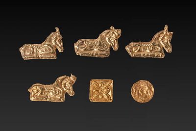 COLLECTION OF GREEK GOLD IBEX AND FLOWER-SHAPED APPLIQUES. Ca. 800 - 300 BC. A collection of six 