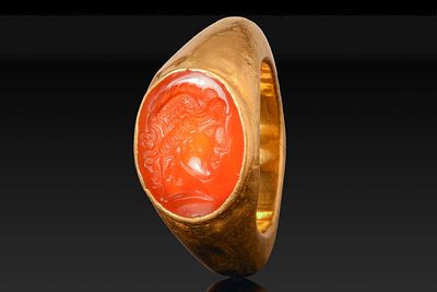 ROMAN GOLD RING WITH CARNELIAN INTAGLIO OF MERCURY. Ca. AD 1 - 50. A gold ring with a broad hoop 