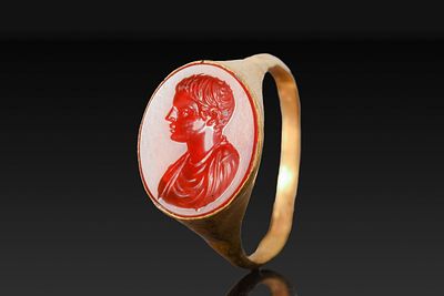 ROMAN GOLD RING WITH CARNELIAN INTAGLIO OF A YOUTH. Ca. AD 1 - 50. A gold ring with a slender 