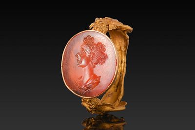 ROMAN GOLD RING WITH SATYRS AND CARNELIAN INTAGLIO OF A NOBLEWOMAN. Ca. AD 300. A gold ring with 