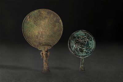 PAIR OF NEAR EASTERN BRONZE MIRRORS. Ca. 2200 - 1500 BC. A pair of bronze mirrors, each with a 