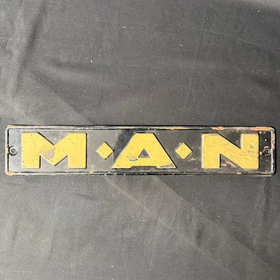 MAN Embossed Metal Truck Sign. Rectangular black and yellow embossed metal sign featuring 
