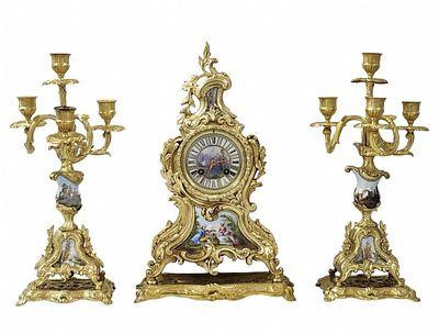 Garniture set includes a mantel clock and pair of matching candelabras, made of gilded Spelter 