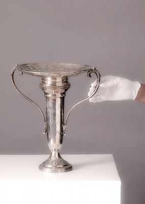 סנטר פיס, עשוי מתכת מצופה כסף, תיקון לבסיס של ידית אחת, חתום. גובה: 33.5 ס"מ רוחב כולל: 31 ס"מ