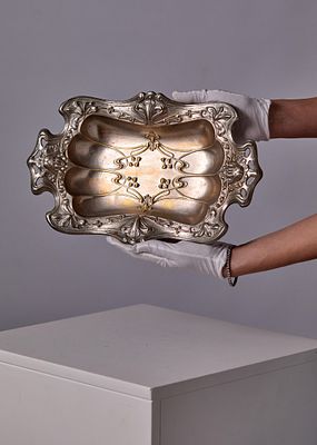 מגש דקורטיבי אר-נובו ממתכת מוכספת - סוף המאה ה־19. עם מסגרת גלית בדגמי עלים ופרחים ודמות נשית 