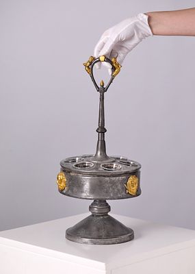 מעמד שולחני גדול ומפואר לרטבים ותבלינים 'Cruet set'. עשוי פיוטר מעוטר ומוזהב בחלקו בקבוקי 