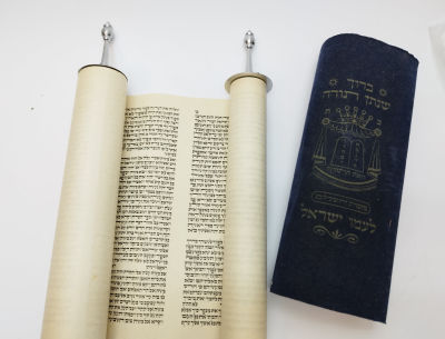 ספר תורה מודפס על גבי נייר. עצי חיים עשויים מתכת.