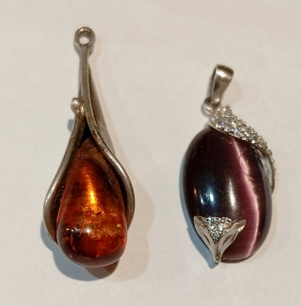 צמד תליוני כסף , האחד משולב ענבר טבעי והשני אבן חן. חתומים