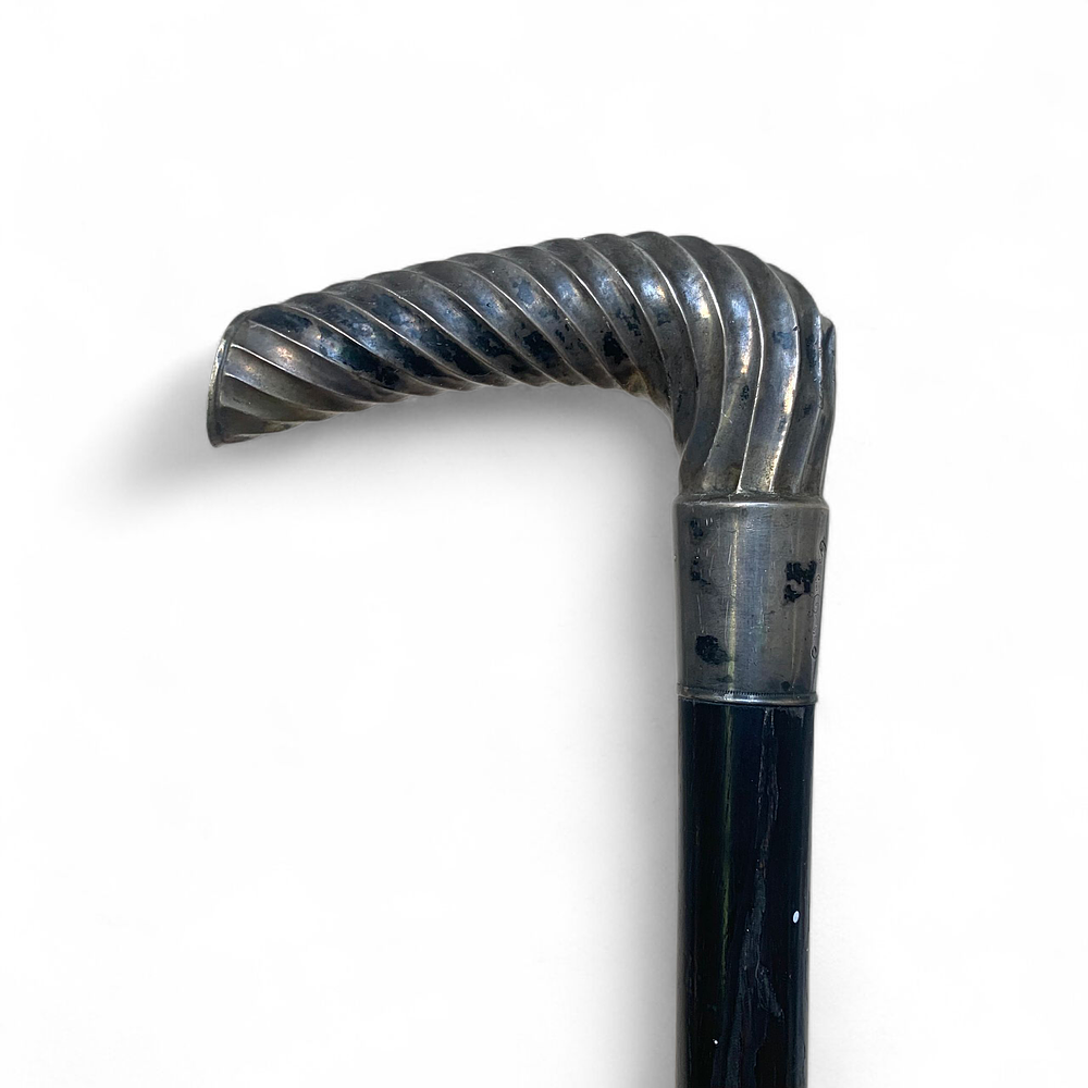 מקל הליכה וינאי, ידית עשויה כסף. חתום. 
מעיכה בצידו האחורי של ראש המקל, טבעת בחלקו התחתון חסרה