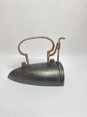 Антикварный утюг 19 века в бронзовом корпусе и металлической ручкой с нагревательным элементом. 