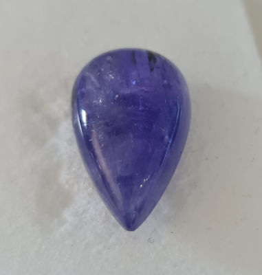 אבן טנזנייט מלוטשת גדולה, 15 קראט, נדירה, תכלילים וערוצים אופייניים, בקופסת תצוגה עם תג מחיר של 