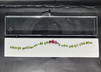 לוט 34 אבני פרידוט ו-3 אבניי טורמלין ורוד מלוטשות סופר AAA+++, משקל כולל 12.85 קראט 